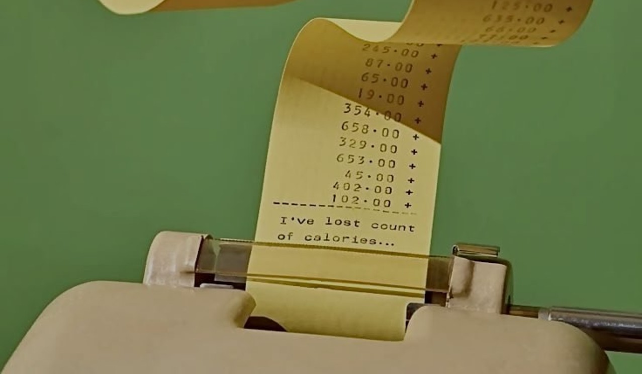 Calculadora antiga imprimindo uma fita com valores somados