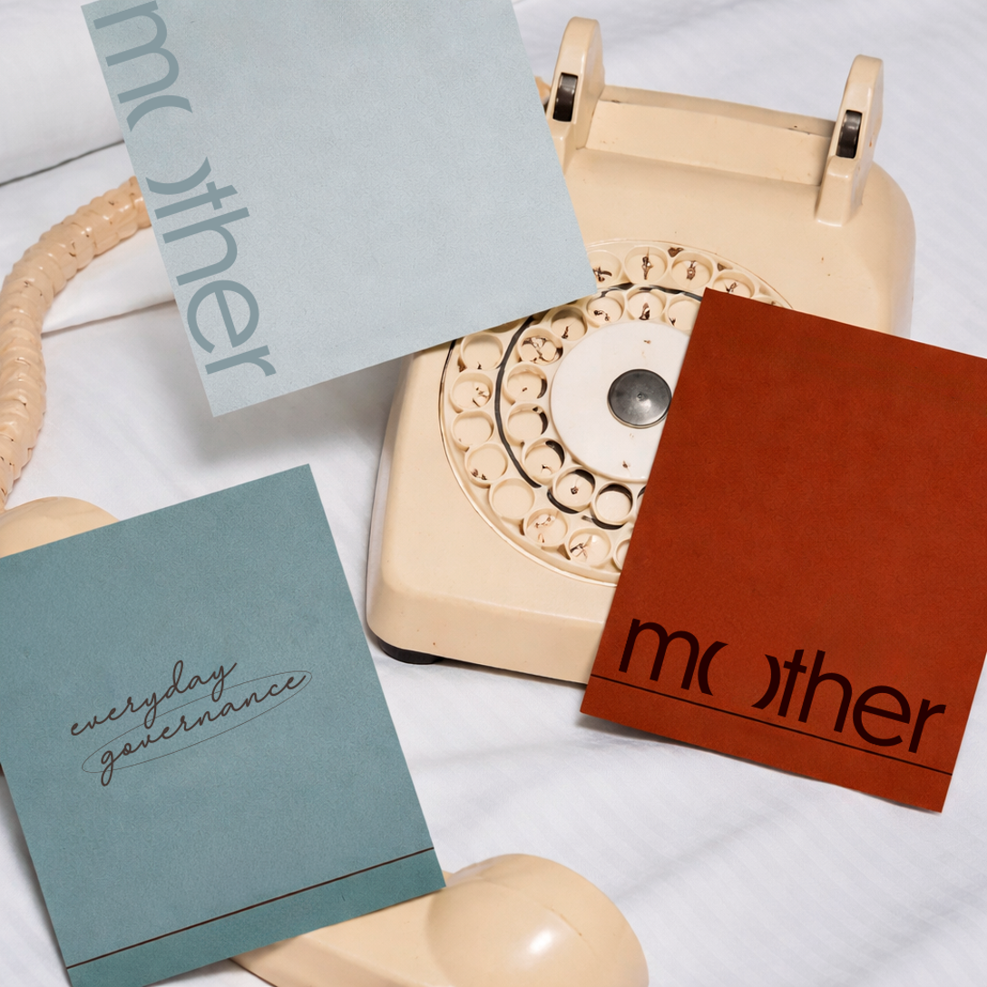 Papelaria da marca Mother — cartões com a assinatura everyday governance ao redor de um telefone vintage